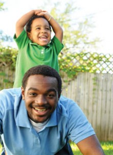 Young boy playing "horsey" with his dad