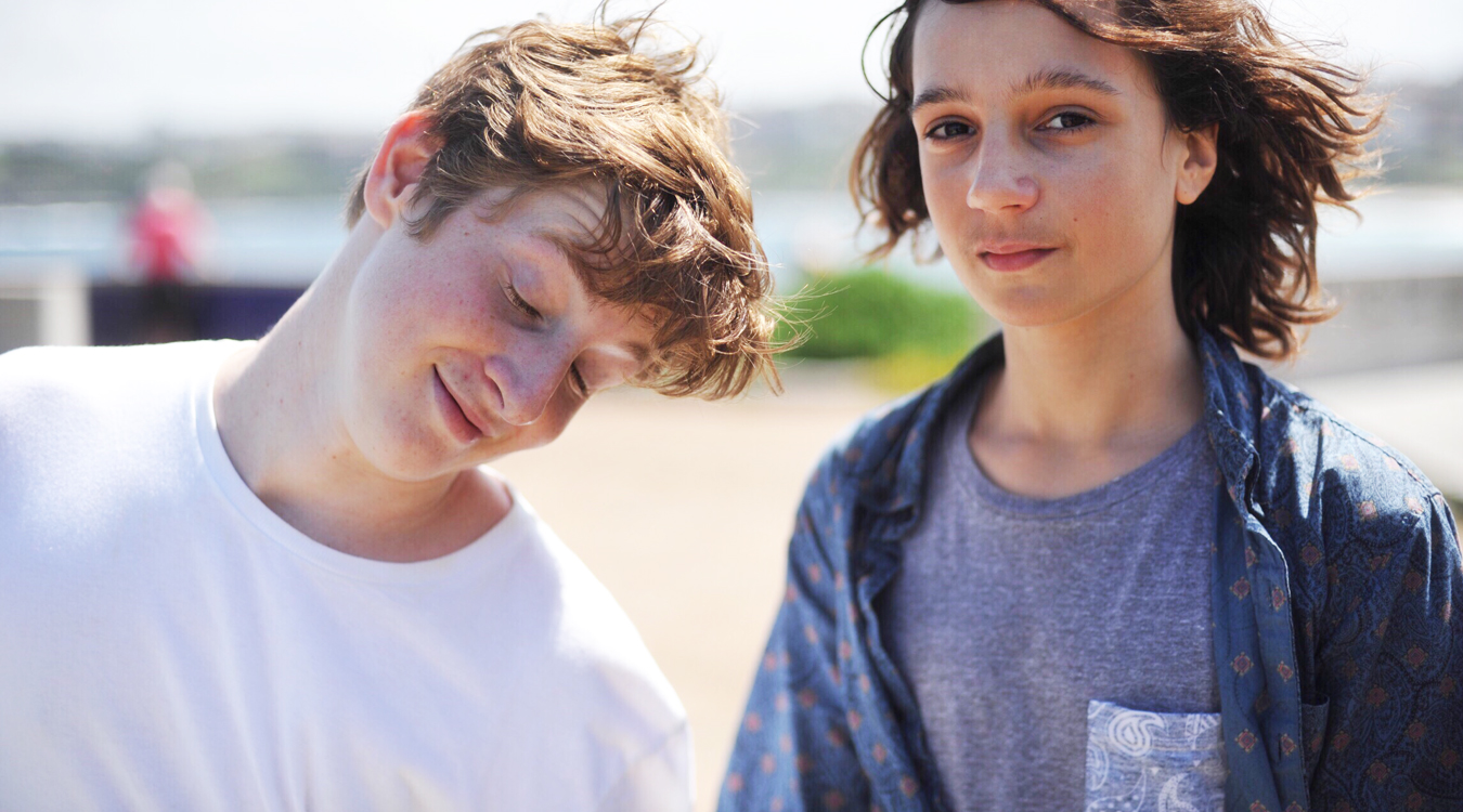 Two teen-aged boys—one being a goofball, one looking into camera.